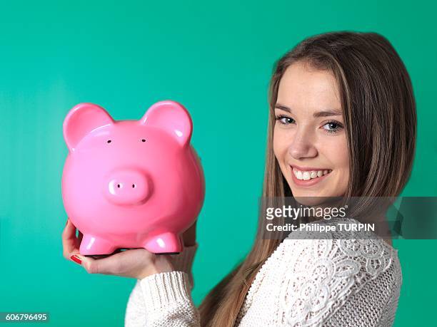 france, teenager in studio with money box - blonde girl piggy bank stock-fotos und bilder