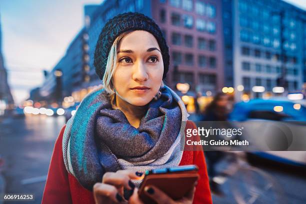 woman using mobile phone in a street. - berlin stock photos et images de collection