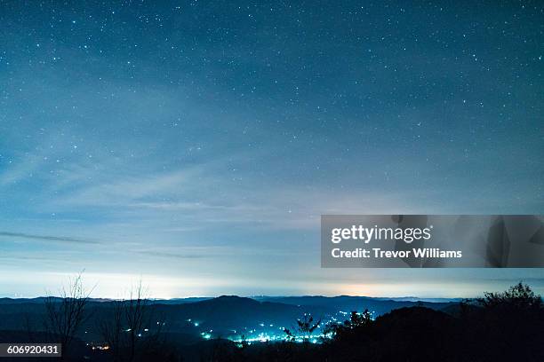 stars fill the sky above small village - star space stock pictures, royalty-free photos & images