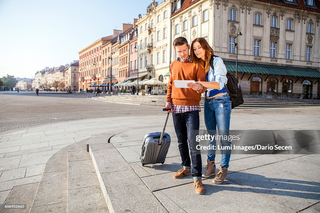 Mid adult couple on a city break using digital tablet