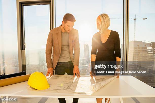 architects in office examining blueprint - dario secen stock-fotos und bilder