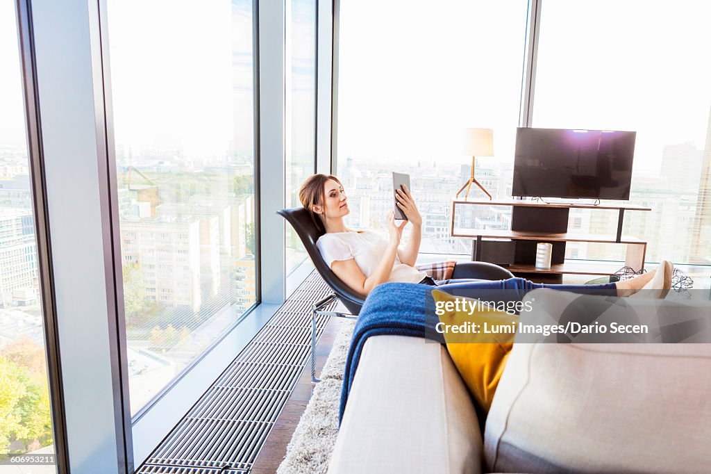 Woman in apartment using digital tablet