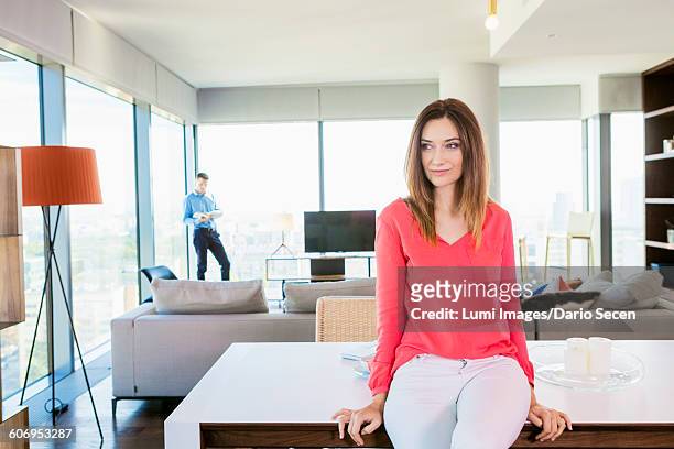 woman in apartment day dreaming with man in background - dario secen stock-fotos und bilder