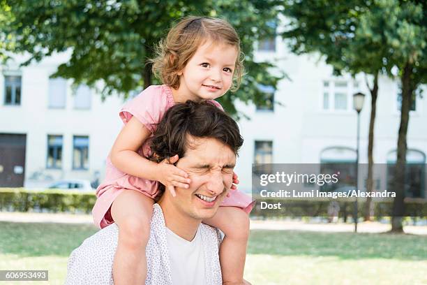 father carrying daughter on shoulders - alexandra dost stockfoto's en -beelden