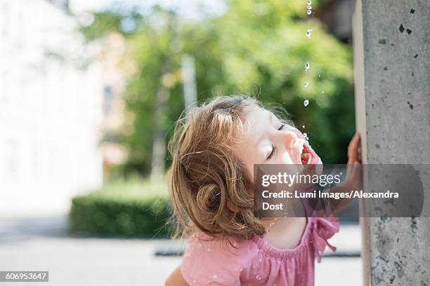 little girl drinking water from fountain - alexandra dost stockfoto's en -beelden