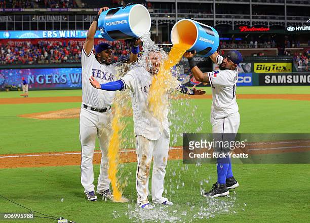 Elvis Andrus of the Texas Rangers and Rougned Odor celebrates by dumping the coolers on Jonathan Lucroy for hitting a two run walk off single against...