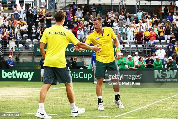 Sam Groth and John Peers of Australia celebrate winning match point in the doubles match against Andrej Martin and Igor Zelenay of Slovakia during...