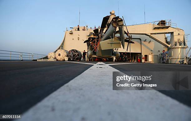 Staff check on helicopter before lifting off the Amphibious transport dock "Kunlun Shan" during China-Russia Naval Drill "Joint Sea-2016" on...