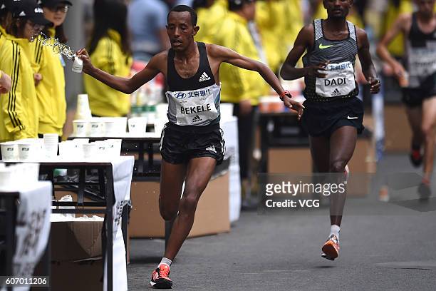 Ethiopia's Kenenisa Bekele takes a cup of water while running during the 2016 Beijing Marathon on September 17, 2016 in Beijing, China. Running from...