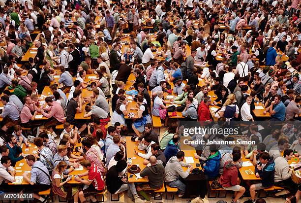 Visitors wait for the kick off the 2016 Oktoberfest beer festival in the Hacker-Pschorr tent at Theresienwiese on September 17, 2016 in Munich,...