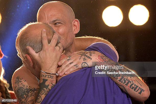 Winner Ben Tewaag is hugged by Mario Basler during the finals of 'Promi Big Brother 2016' at MMC Studios on September 16, 2016 in Cologne, Germany.