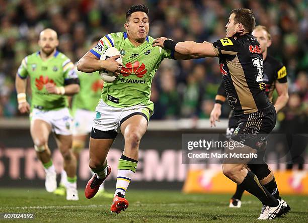 Joseph Tapine of the Raiders hands off Trent Merrin of the Panthers during the second NRL Semi Final match between the Canberra Raiders and the...