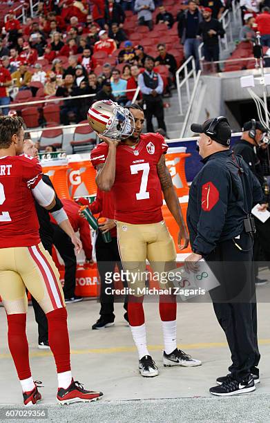 Colin Kaepernick and Head Coach Chip Kelly of the San Francisco 49ers talk on the sideline following the anthem, prior to the game against the Los...
