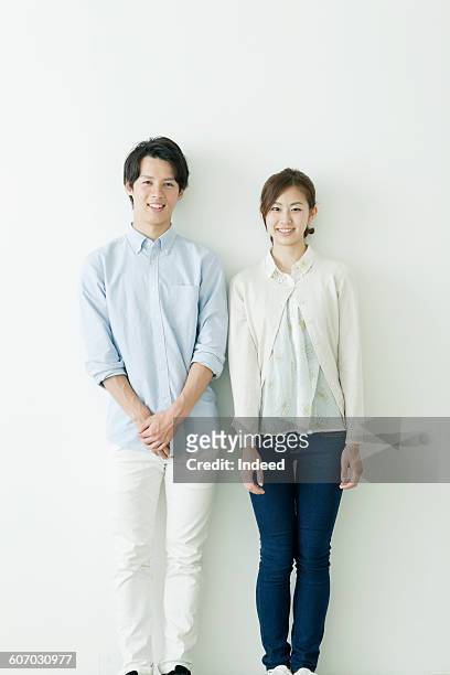 portrait of young man and woman - 手を重ねる ストックフォトと画像