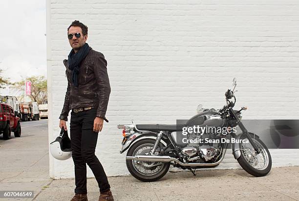 middle-aged man standing next to his motorcycle - leather pants photos et images de collection