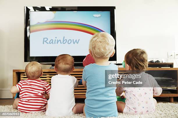 four babies sat in front of television - boy watching tv stock pictures, royalty-free photos & images