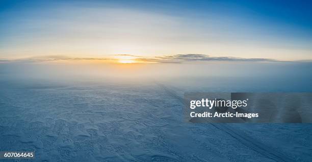 fog and sunset over snowy road, iceland - pack ice stockfoto's en -beelden