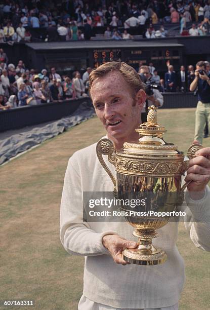 Rod Laver of Australia stands holding the Gentlemen's singles trophy after winning the Men's Singles final against his fellow countryman Tony Roche...