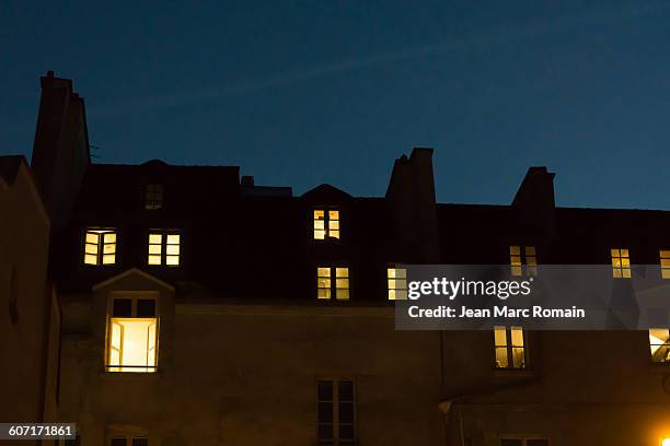 lighted windows at night - façade immeuble photos et images de collection