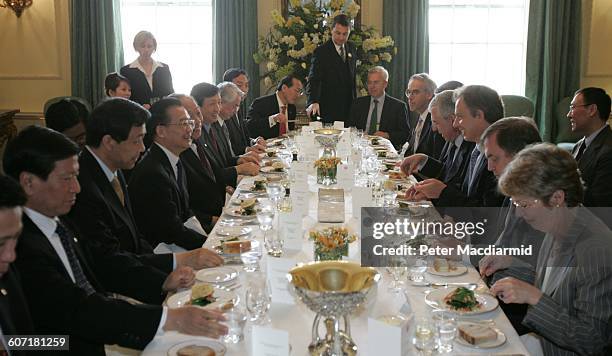 Chinese Premier Wen Jiabao and British Prime Minister Tony Blair share a laugh over a meal at 10 Downing Street, London, England, May 10, 2004.