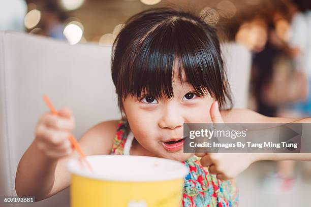 little girl having snack joyfully in cafe - chinese yoghurt stock pictures, royalty-free photos & images