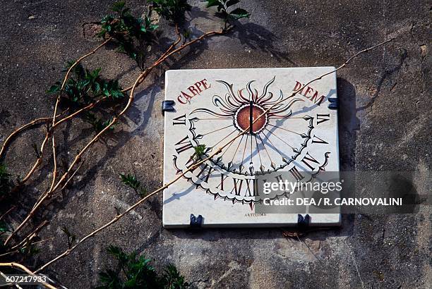 Sundial on the wall of a building in Lucignano d'Asso, Tuscany, Italy.