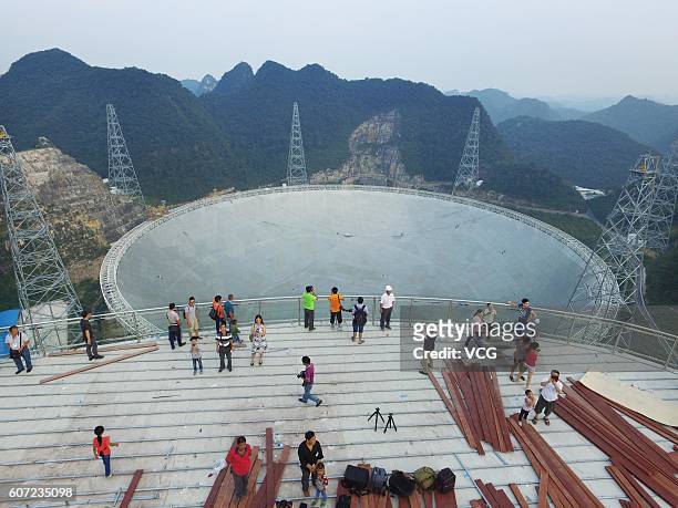 Aerial view of tourists looking at a dish-like radio telescope at Pingtang County on September 17, 2016 in Qiannan Buyei and Miao Autonomous...