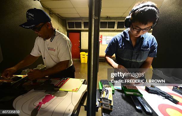 Gun enthusiasts load their weapons for target practice at the LAX Firing Range in Inglewood, California on September 7, 2016. / AFP / Frederic J....