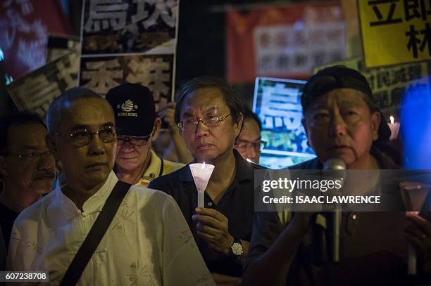 Protesters attend a candle light vigile for the southern Chinese village of Wukan outside the Chinese Liason Office in Hong Kong on September 17,...