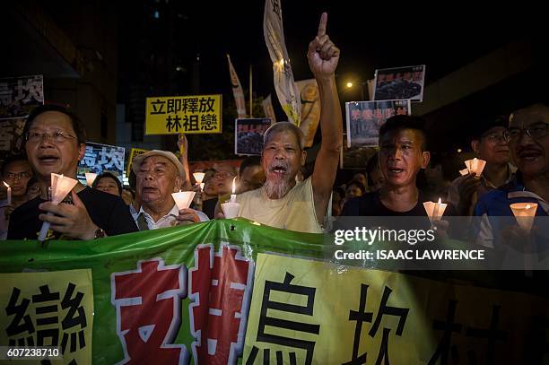 Protesters attend a candle light vigile for the southern Chinese village of Wukan outside the Chinese Liason Office in Hong Kong on September 17,...