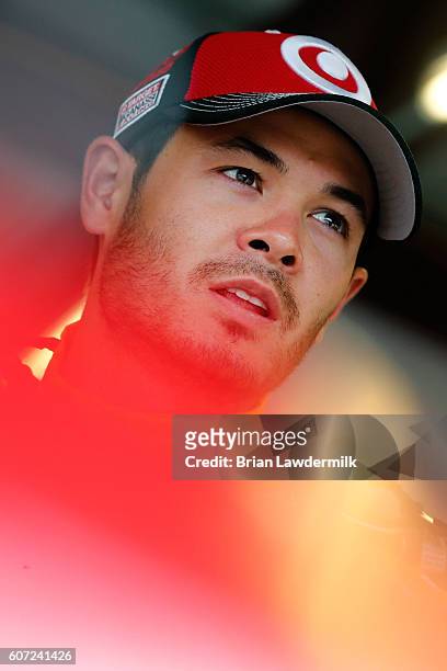 Kyle Larson, driver of the Coke Chevrolet, stands in the garage area during practice for the NASCAR Sprint Cup Series Teenage Mutant Ninja Turtles...