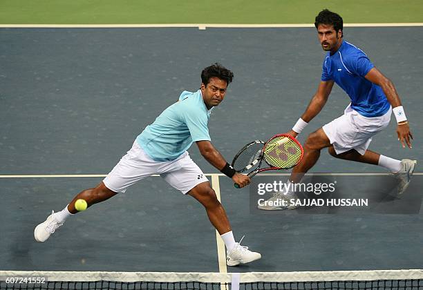 India's Leander Peas hits a return alongside teammate Saketh Myneni during their doubles tennis match against Spain's Rafael Nadal and Marc Lopez...