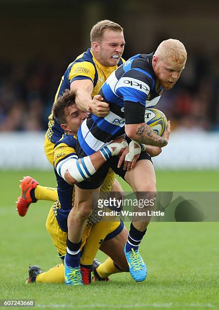 Tom Homer of Bath Rugby is tackled by Perry Humphreys and Wynand Olivier of Worcester Warriors during the Aviva Premiership match between Bath Rugby...