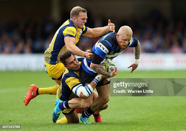 Tom Homer of Bath Rugby is tackled by Perry Humphreys and Wynand Olivier of Worcester Warriors during the Aviva Premiership match between Bath Rugby...