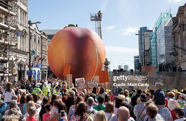 Members of the public gather to watch a giant peach as it is moved through the centre of Cardiff as part of a street performance to mark the start of...