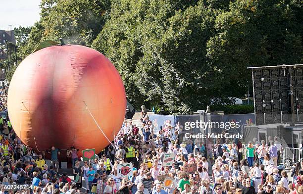 Members of the public gather in front of Cardiff Castle to watch a giant peach being moved through the centre of Cardiff as part of a street...