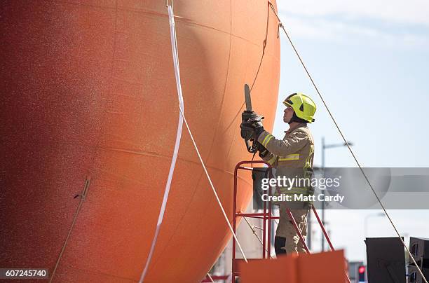 Members of the public gather to watch a giant peach as it is moved through the centre of Cardiff as part of a street performance to mark the start of...