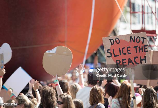 Members of the public gather to watch a giant peach as it is moved through the centre of Cardiff as part of a street performance to mark the start of...