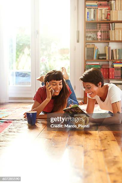 two young women relaxing at home enjoying free time - cool couple in apartment stock pictures, royalty-free photos & images