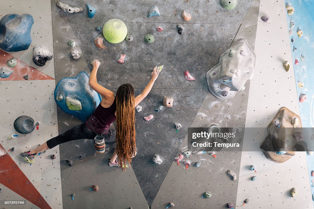 Indoor climbing in the bouldering gym wall.