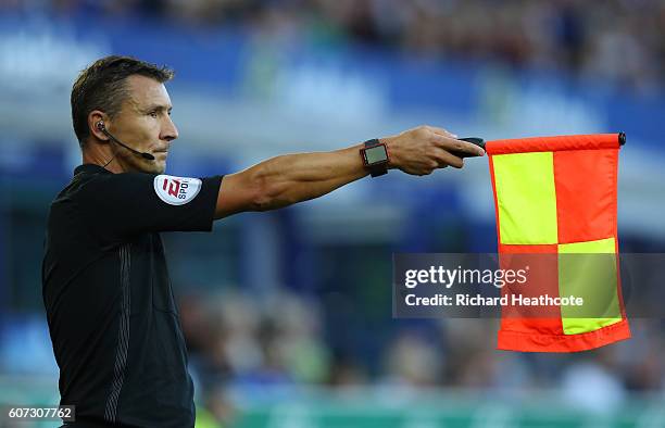 The assisstant referee holds up the offside flag during the Premier League match between Everton and Middlesbrough at Goodison Park on September 17,...