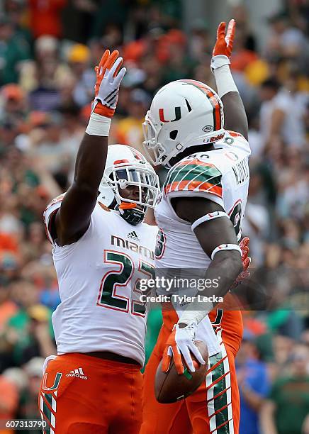 David Njoku of the Miami Hurricanes celebrates after scoring a touchdown with teammate Christopher Herndon IV during their game against the...