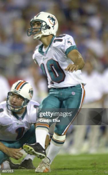 Matt Turk of the Miami Dolphins holds the ball as teammate Olindo Mare attempts the field goal during the game against the Tennessee Titans at...