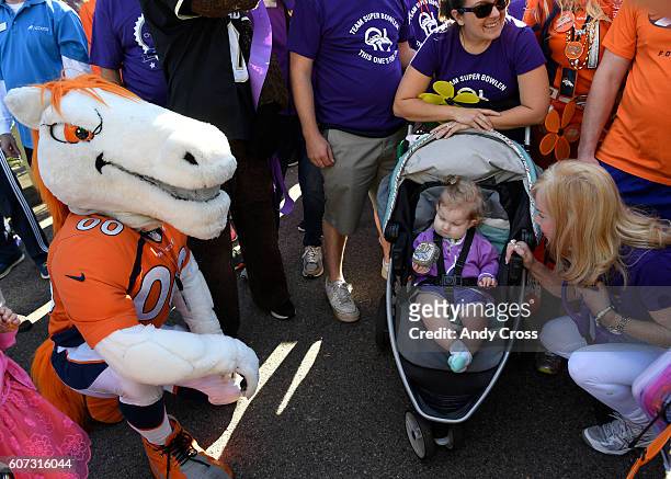 September 17: Annabel Bowlen, lower right, crouches down next to her 15-month-old granddaughter Marley who is holding Denver Broncos mascot Miles'...