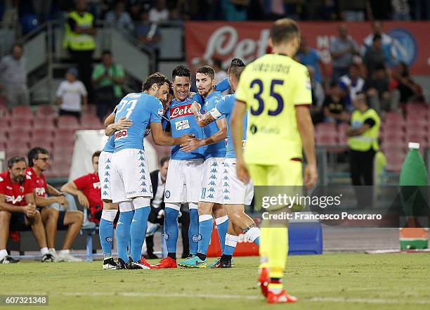 Napolis players celebrate after scoring the 1-0 goal, beside the disappointment of Vasilis Torosidis of Bologna FC during the Serie A match between...