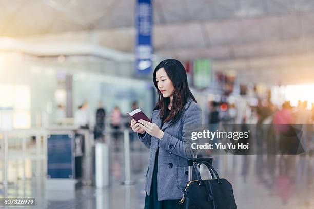 woman with passport and boarding pass in airport - yiu yu hoi stock pictures, royalty-free photos & images