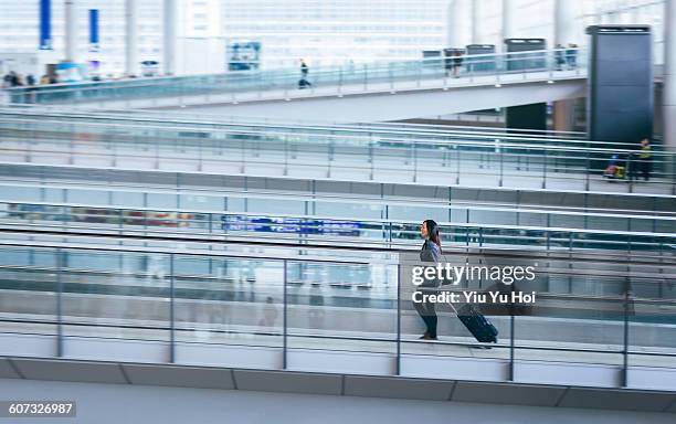 businesswoman pulling suitcase in airport - yiu yu hoi stock pictures, royalty-free photos & images