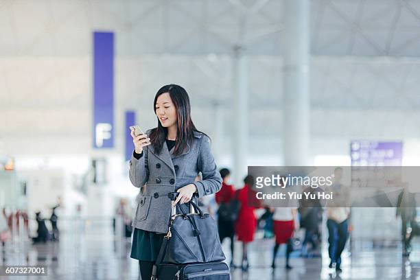 businesswoman using cellphone in airport concourse - yiu yu hoi stock pictures, royalty-free photos & images