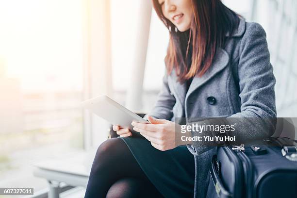 businesswoman using digital tablet in airport - yiu yu hoi stock pictures, royalty-free photos & images