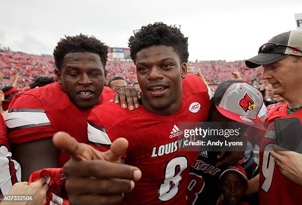 Lamar Jackson of the Louisville Cardinals celebrates with teammates after the 63-20 win over the Florida State Seminoles at Papa John's Cardinal...